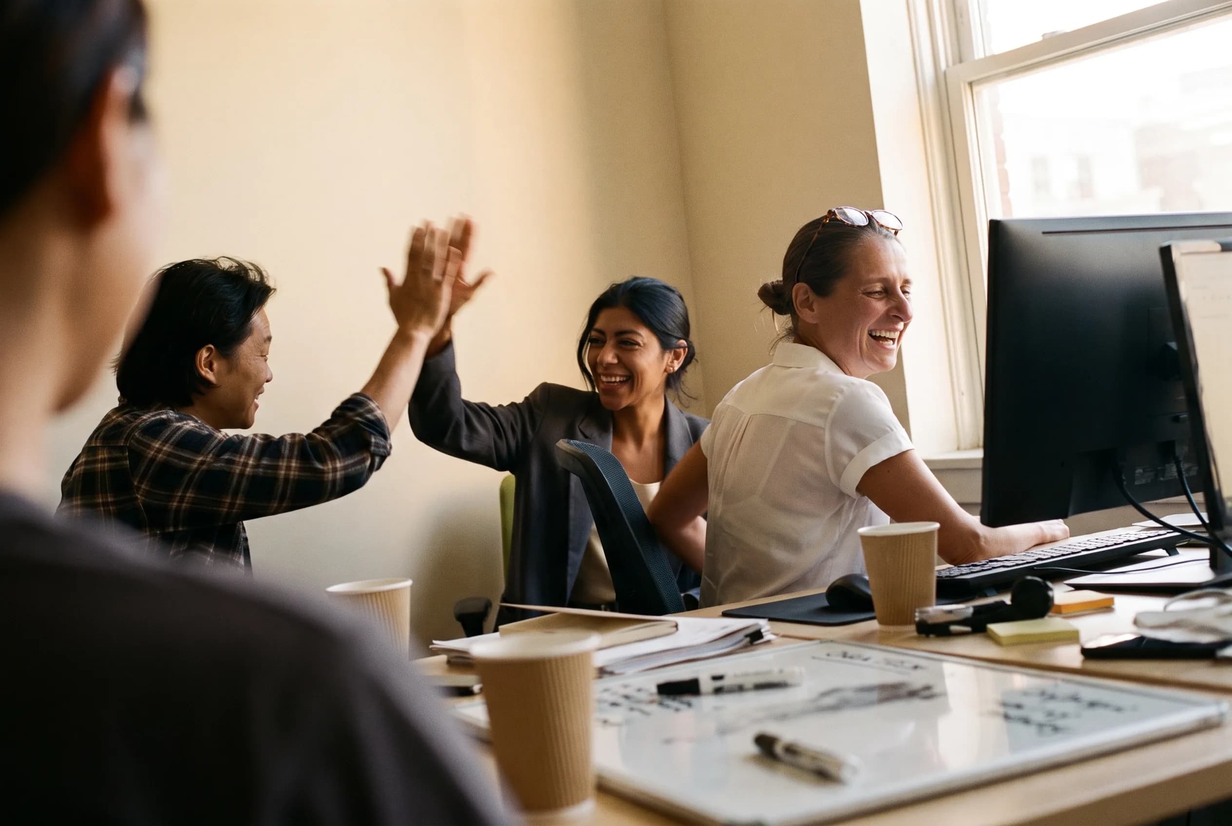 A hiring team's unguarded high-five after closing a role.