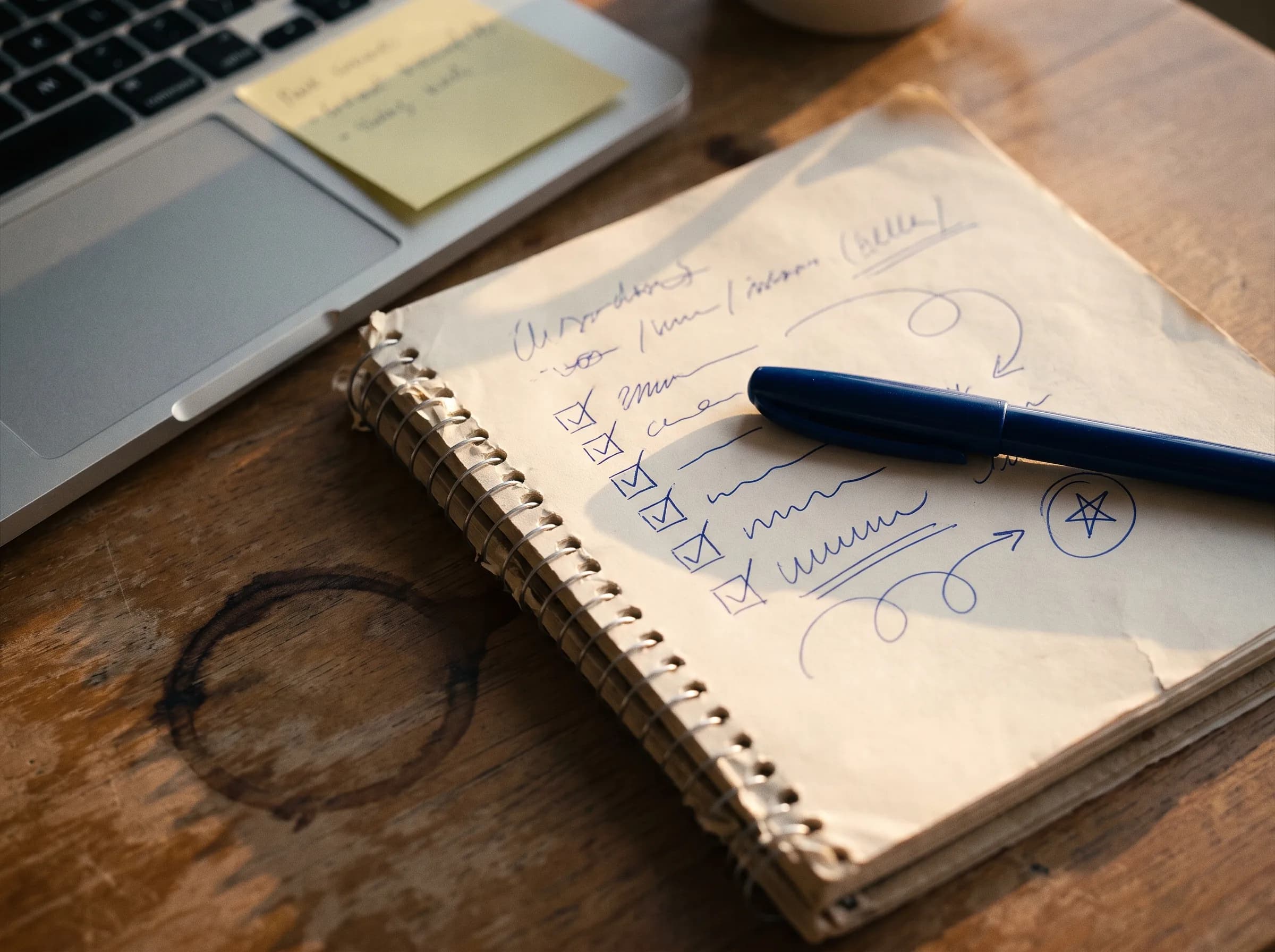 Interview-day notes and checkmarks in a notebook beside a laptop.